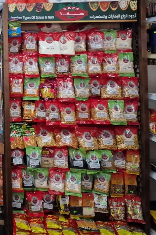A tall display of Safa spices, nuts and seeds in red and green packets.